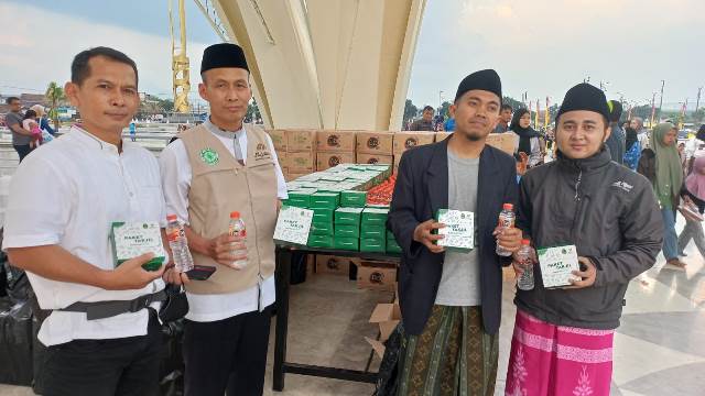 Pengurus DKM Bidang Pemakmuran KH Erdi Hardiman (rompi) membantu pembagian paket buka puasa di Masjid Raya Al Jabbar.